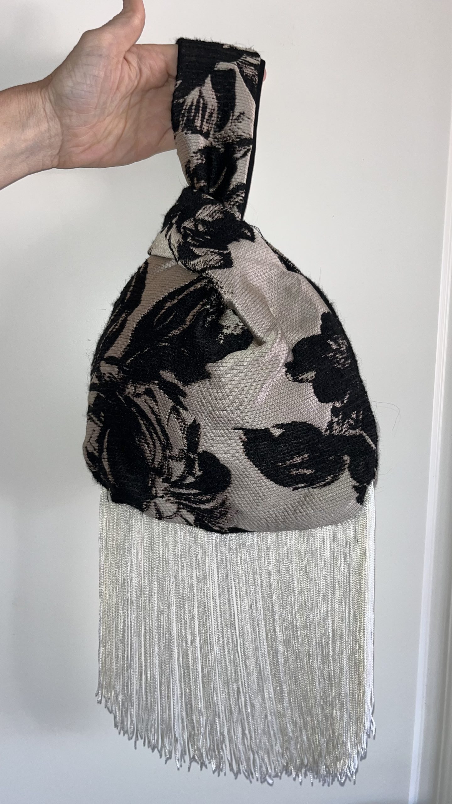 Bolso floral negro y beige con flecos blancos de ÁKAPE