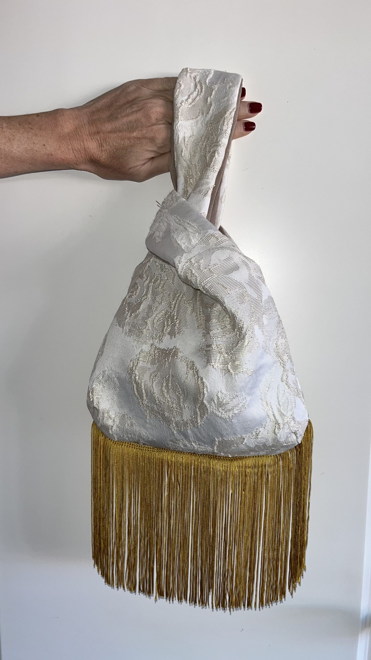 Bolso blanco con flecos dorados de ÁKAPE